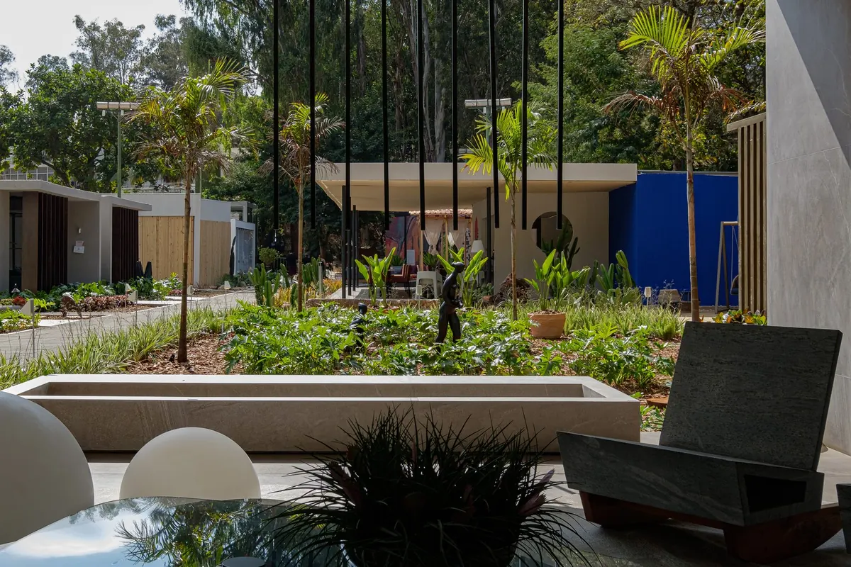 Jardim com espelho d'água em pedra e espreguiçadeira de design